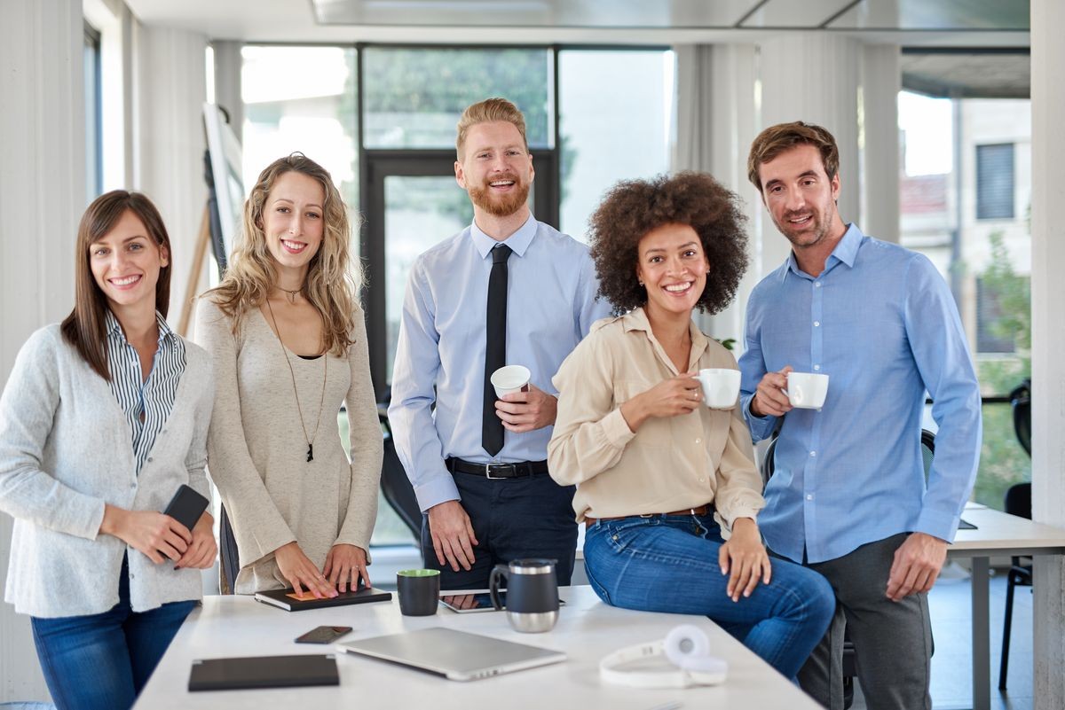 Cheerful group of business people posing in office. Multicultural group. Start up business concept. Cheerful group of business people posing in office. Multicultural group. Start up business concept.